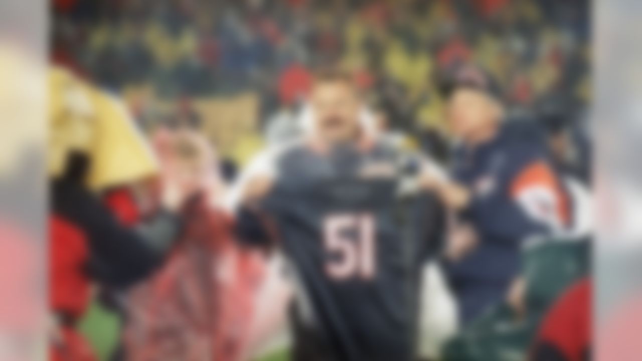 Former Chicago bears linebacker Dick Butkus holds up his jersey after the team retired his number (51) during halftime ceremonies of the Packers-Bears game Monday night, October 31, 1994, at Chicago's soldier field. At right is the Bear's team president Mike McCaskey. (Fred Jewell/Associated Press)