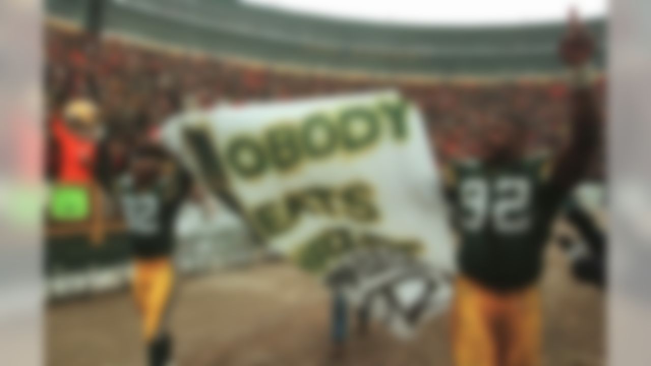 Green Bay Packers' Reggie White (92) and Mark Ingram (82) carry a banner around Lambeau Field Sunday, Dec. 24, 1995, after beating the Pittsburgh Steelers 24-19 to win the NFC Central title in Green Bay, Wis. (AP Photo/Morry Gash)