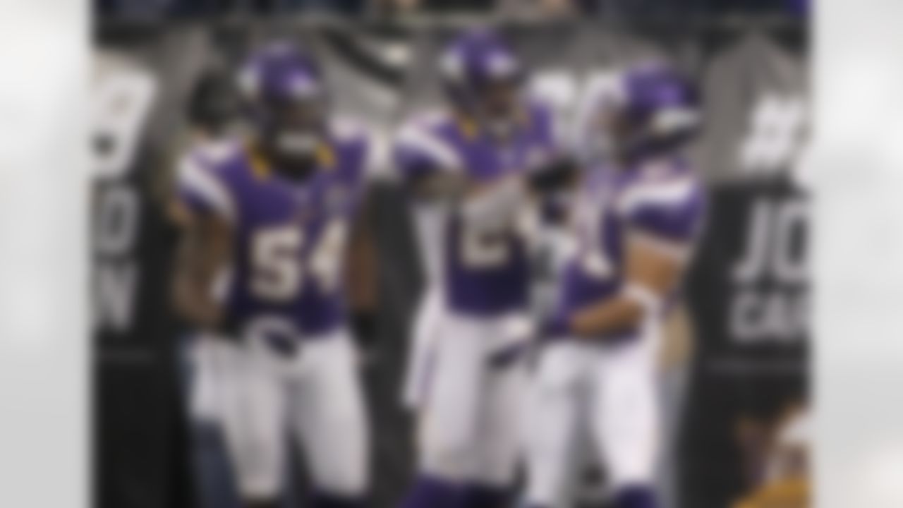 Minnesota Vikings' Josh Robinson, right, celebrates his touchdown interception with teammates A.J. Jefferson, center, and Jasper Brinkley during the first half of an NFL football game against the Chicago Bears Sunday, Dec. 9, 2012, in Minneapolis. (AP Photo/Andy King)
