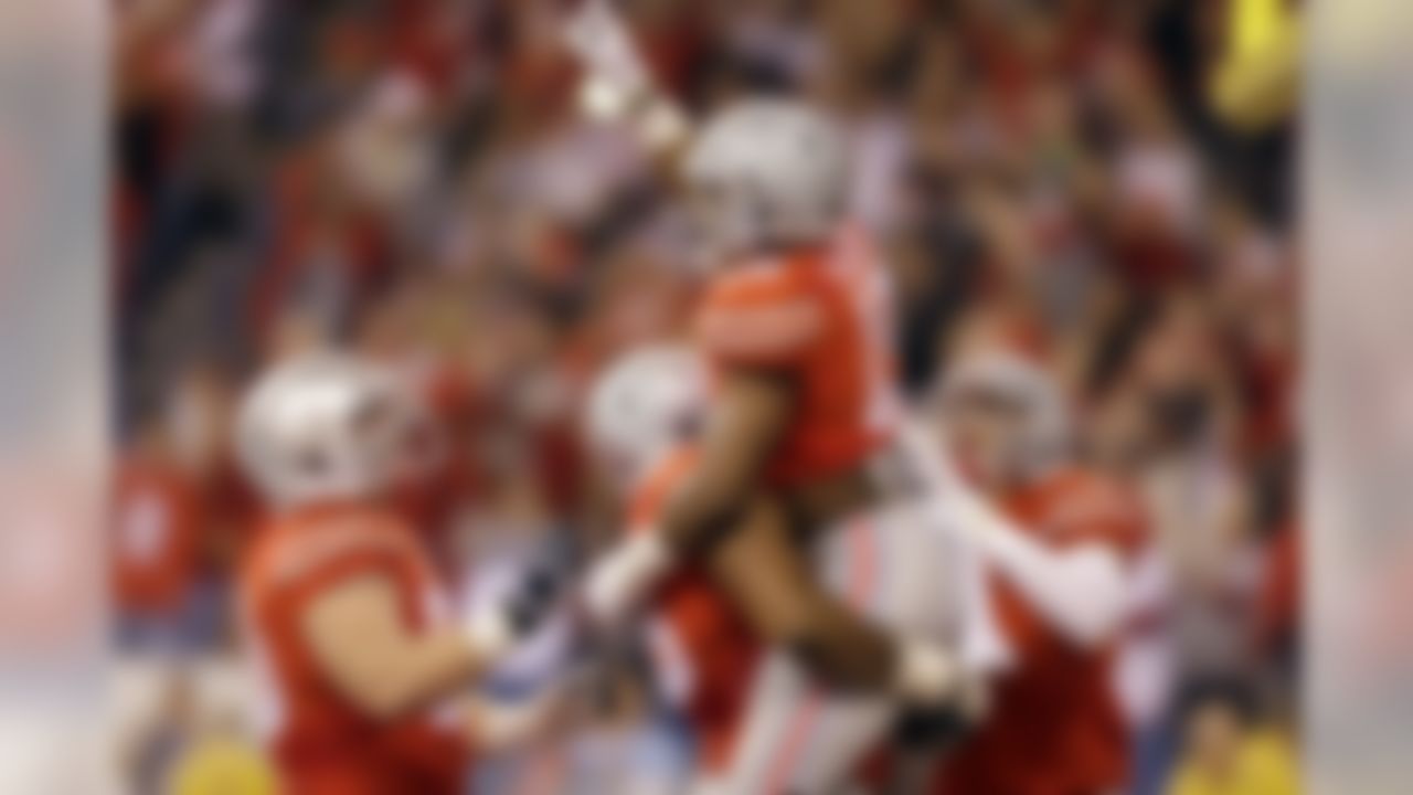 Ohio State running back Ezekiel Elliott is congratulated by teammates after scoring on a 14-yard touchdown run during the first half of the Big Ten Conference championship NCAA college football game against Wisconsin Saturday, Dec. 6, 2014, in Indianapolis.