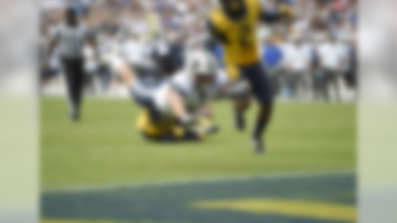 BYU wide receiver Mitchell Juergens, left, dives for the end zone for a touchdown past West Virginia safety Jeremy Tyler (2) during the first half of an NCAA college football game, Saturday, Sept. 24, 2016, in Landover, Md. (AP Photo/Nick Wass)