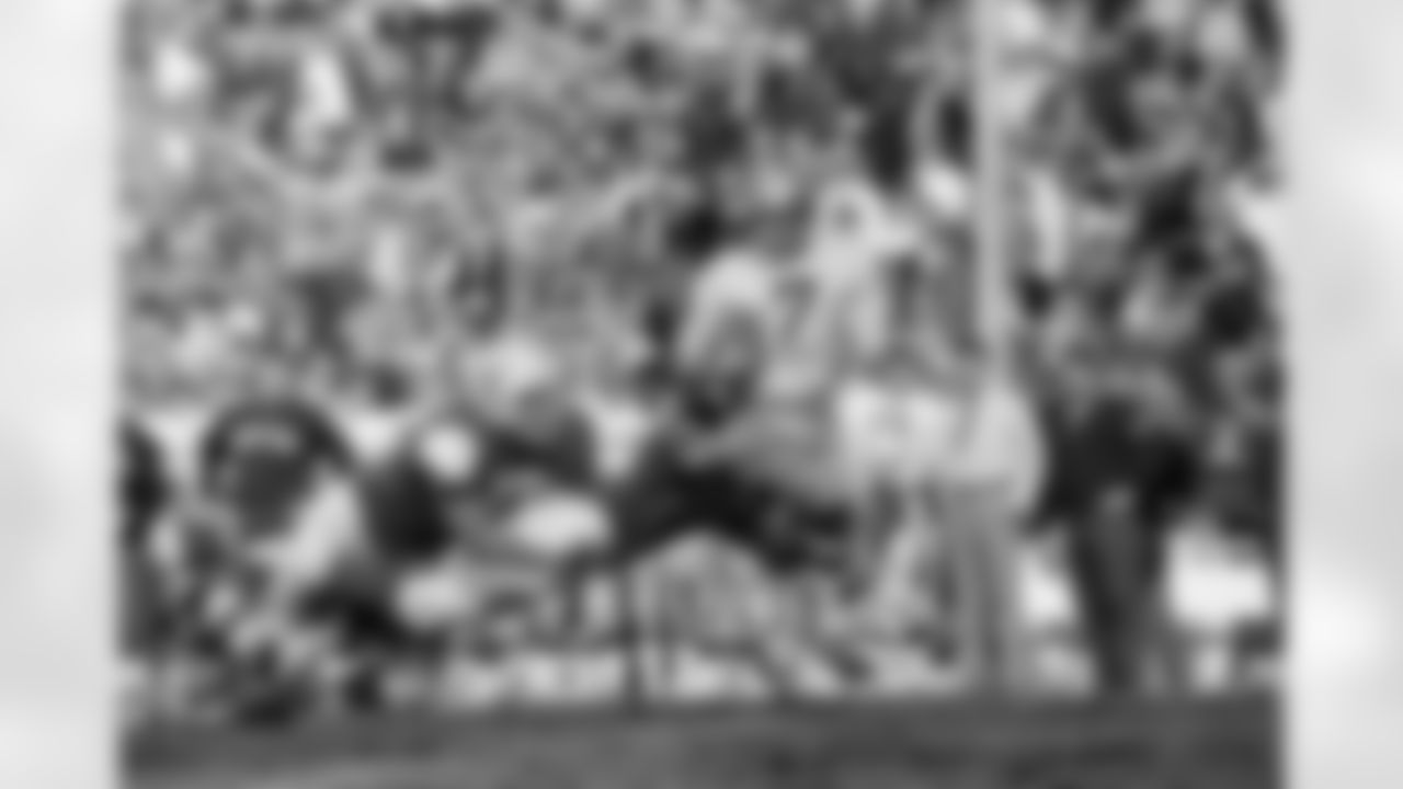 Notre Dame quarterback Joe Theismann (7) breaks away from University of Texas tacklers Bill Atessis (77) and David Arledge (89) and went around left end for a eight yard gain in third quarter of their game in the Cotton Bowl in Dallas, Texas on Jan. 1, 1970. Texas defeated the Fighting Irish, 21-17. (Associated Press)