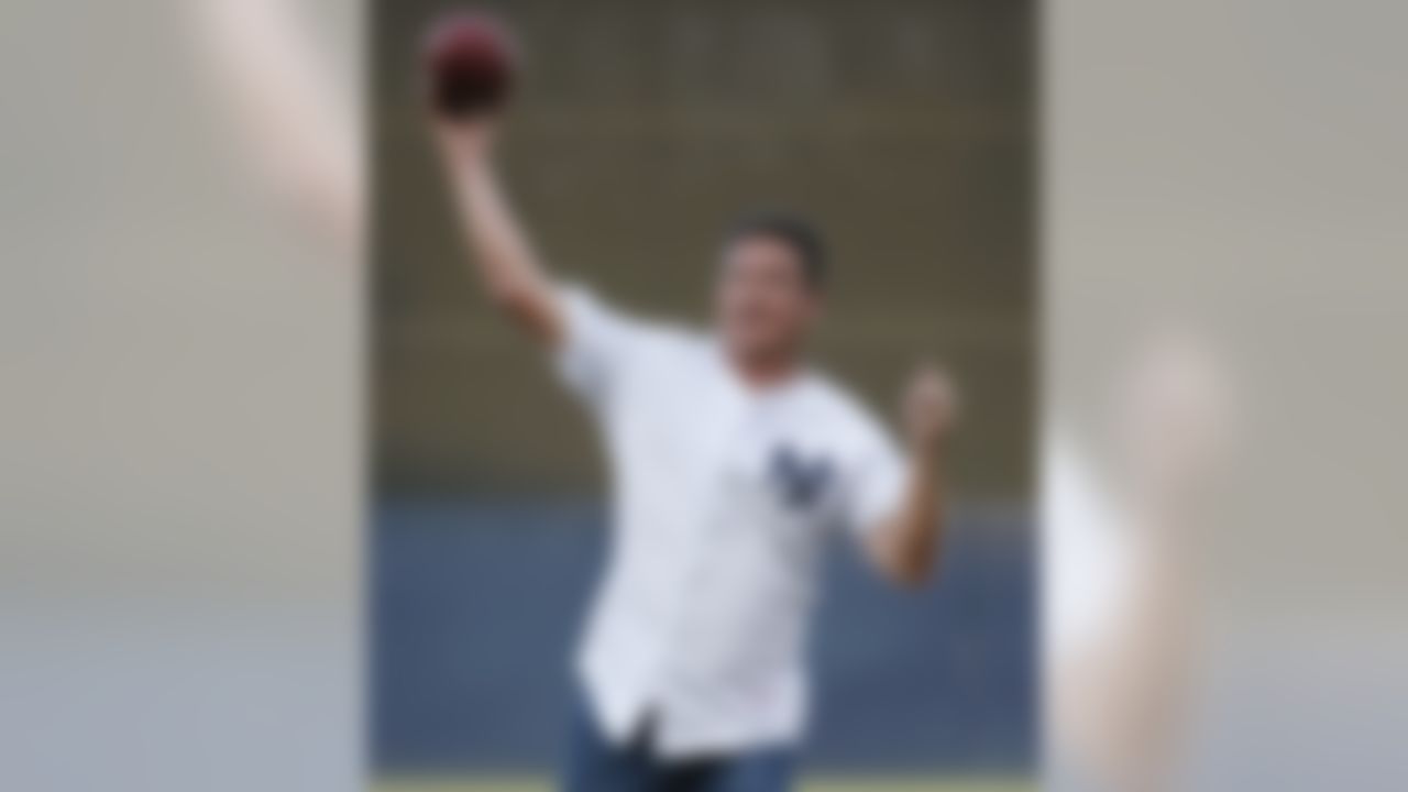 Former Miami Dolphins quarterback Dan Marino throws a football from the mound after throwing out the ceremonial first pitch before a spring exhibition baseball game between the Pittsburgh Pirates and the New York Yankees in Tampa, Fla., Friday, March 21, 2014. (AP Photo/Kathy Willens)