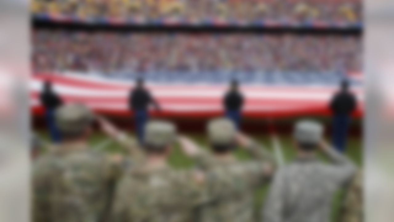 Service members salute the flag before an NFL football game between the Washington Redskins and the Minnesota Vikings in Landover, Md., Sunday, Nov. 12, 2017.