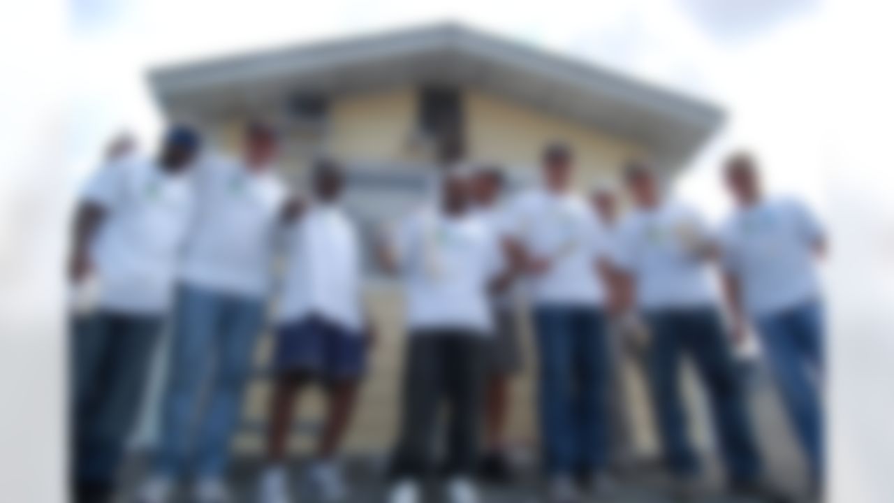 Members of the New Orleans Saints help to rebuild a home ravaged by Hurricane Katrina in New Orleans, Louisiana on June 10, 2008.