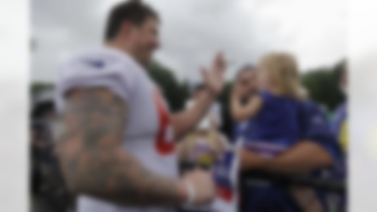 New York Giants tackle David Diehl, left, trades a high five with a young fan as her father holds her during autograph day following a team practice at the New York Giants NFL football training camp in Albany, N.Y., Saturday, July 28, 2012. (AP Photo/Kathy Willens)