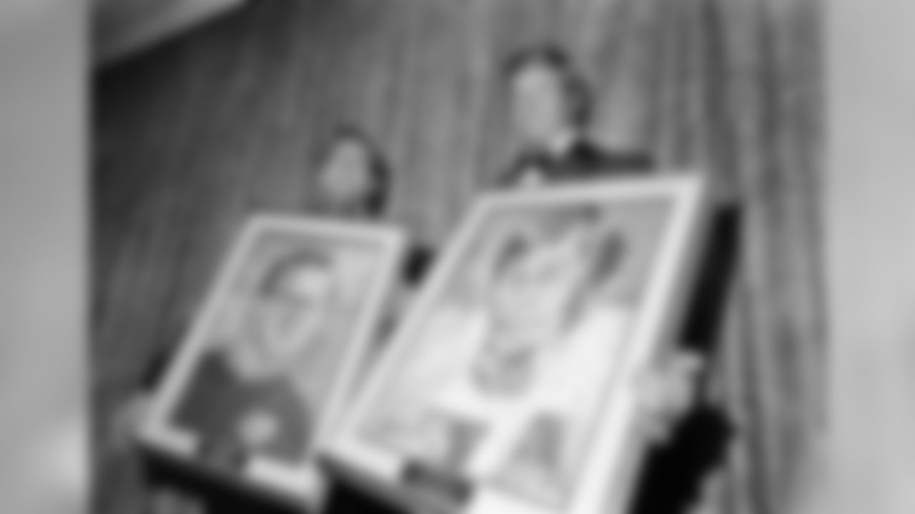 Lamar Hunt, left, owner of the Kansas City Chiefs, and Bob Lilly, tackle for the Dallas Cowboys, display portraits of themselves, May 22, 1972 at a dinner of the Football Writers of America in New York's Americana Hotel. (AP Photo/May 22, 1972. (AP Photo/John Lent)