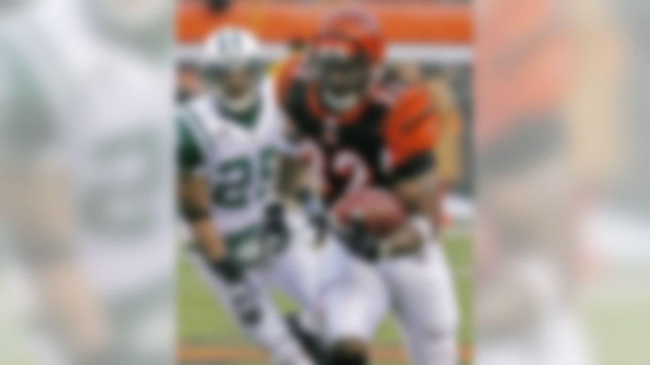 Cincinnati Bengals running back Cedric Benson (32) runs past New York Jets safety Kerry Rhodes (25) in the first half of an NFL wild-card playoff football game, Saturday, Jan. 9, 2010, in Cincinnati. (AP Photo/David Kohl)