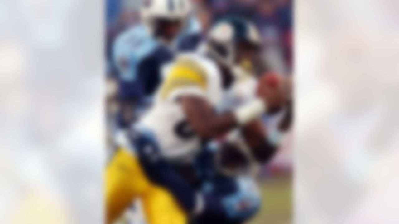 Pittsburgh Steelers wide receiver Plaxico Burress (80) hangs on between Tennessee Titans safety Lance Schulters (31) and cornerback Samari Rolle (21) during the second quarter of their AFC divisional playoff game Saturday, Jan. 11, 2003 in Nashville, Tenn. (AP Photo/Dave Martin)