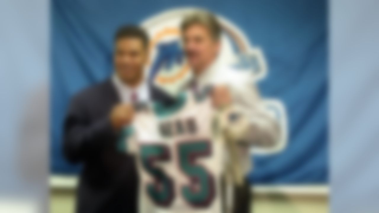 Miami Dolphins coach Dave Wannstedt, right, and Junior Seau, the team's new linebacker, pose with Seau's new Dolphins jersey at a news conference, Wednesday, April 16, 2003, in Davie, Fla. Seau joined the Dolphins on Wednesday after passing a physical, completing a long-anticipated trade with the San Diego Chargers. (AP Photo/J.Pat Carter)