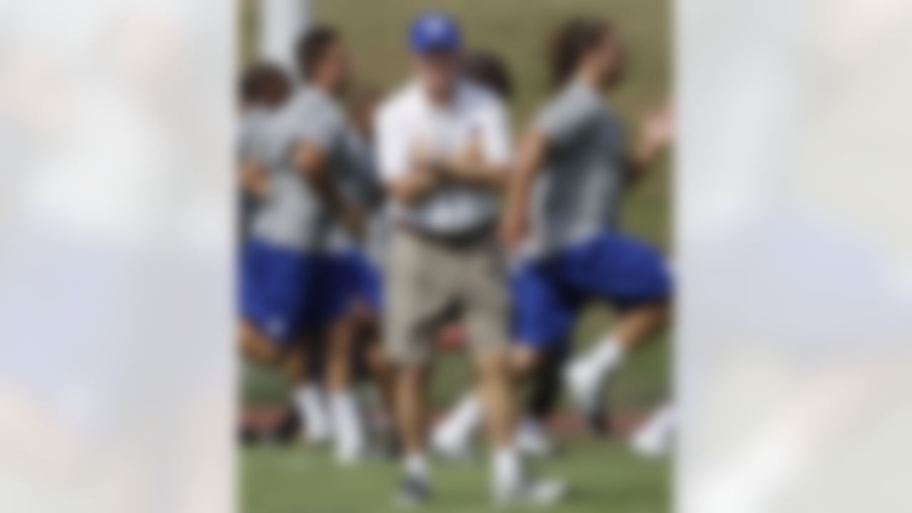 New York Giants head coach Tom Coughlin, center,looks on as field as players, including defensive tackle Markus Kuhn, right, run through a physical evaluation drill on opening day of NFL football training camp in Albany, N.Y., Thursday, July 26, 2012. (AP Photo/Kathy Willens)