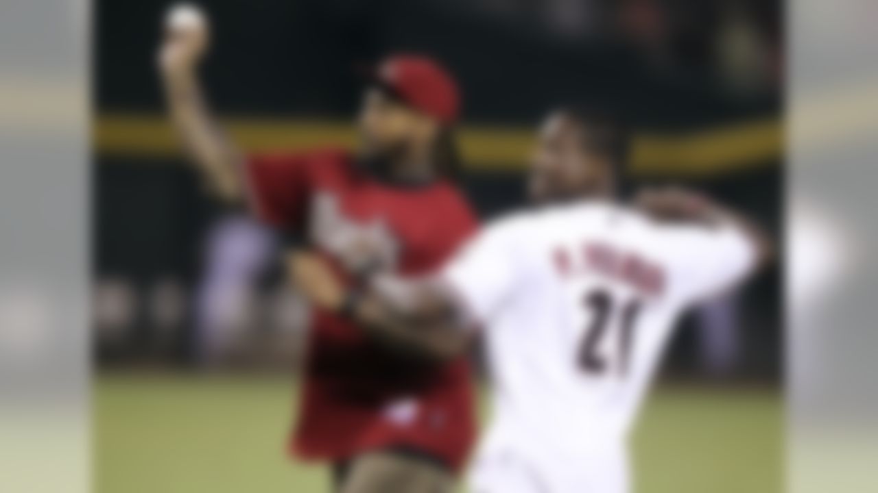 Arizona Cardinals' Darnell Dockett, left, and Patrick Peterson, right, throw out the ceremonial first pitches prior to a baseball game between the Arizona Diamondbacks and Colorado Rockies, Tuesday, Oct. 2, 2012, in Phoenix. (AP Photo/Paul Connors)