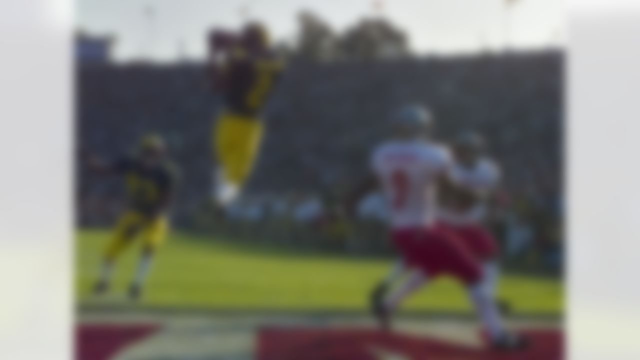 Michigan's cornerback Charles Woodson (2) leaps to make an interception in the end zone in the first half on a pass from Washington State's Ryan Leaf during the 84th Rose Bowl in Pasadena, Calif., Thursday, Jan. 1, 1998. Watching the play are Michigan's William Peterson (23) and Washington States Kevin McKenzie (9). Player at right unidentified. (AP Photo/Mark J. Terrill)