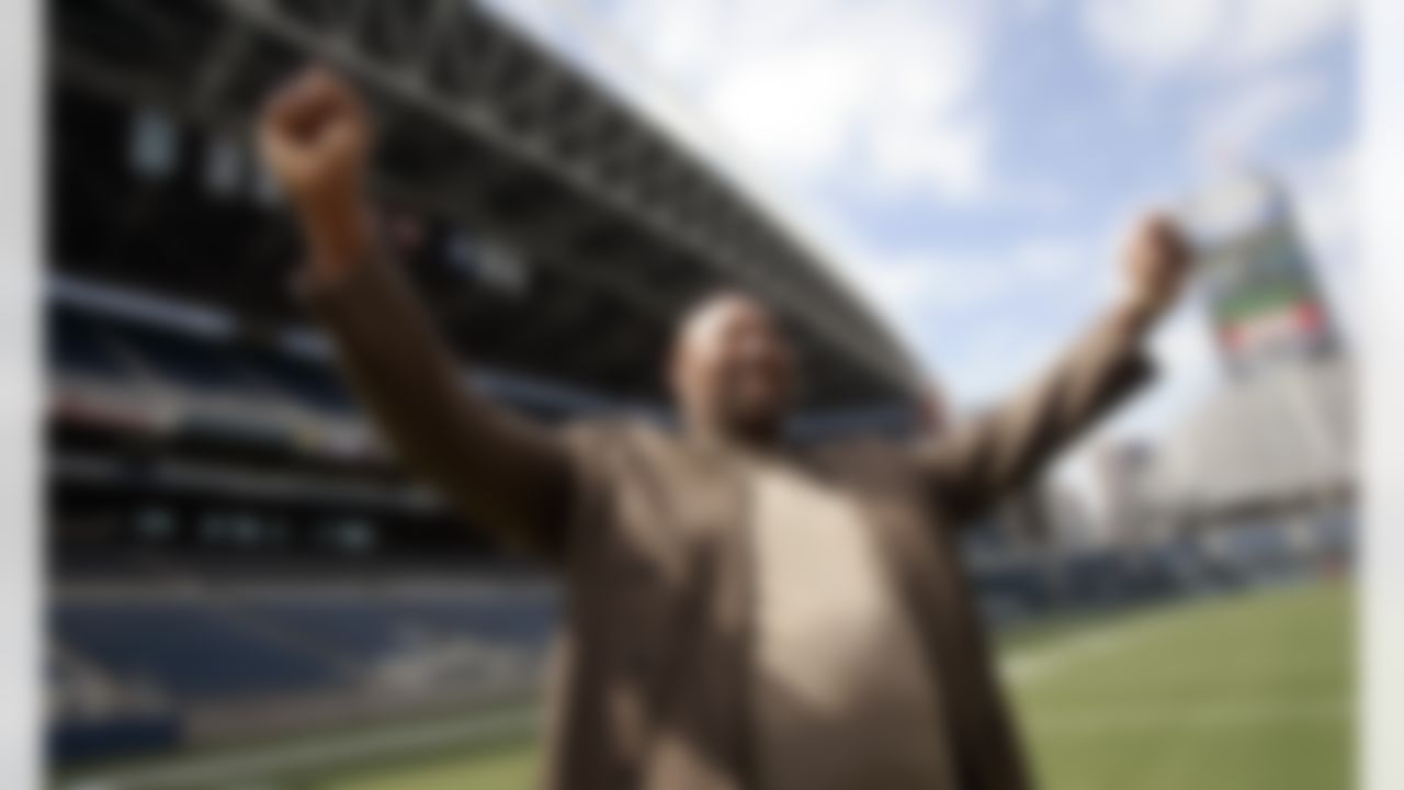 Former Seattle Seahawks tackle Cortez Kennedy raises his arms as he talks with a reporter about recently finishing his college degree, Friday, Aug. 11, 2006, following a news conference at the football team's stadium in Seattle. It was announced that Kennedy will become the 10th member of the Seahawks Ring of Honor during halftime of a game Sept. 17 in Seattle. (AP Photo/Elaine Thompson)