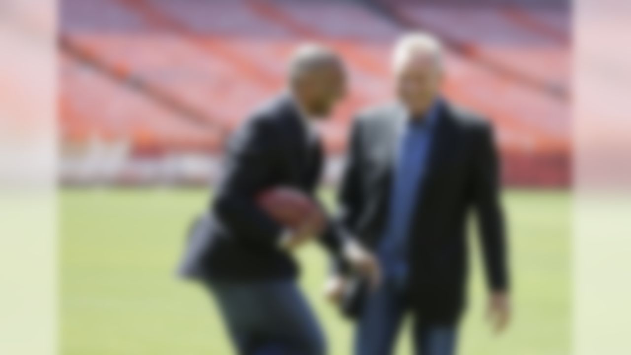 San Francisco 49ers Hall of Fame quarterback Joe Montana, right, laughs as retired running back Roger Craig, left, carries the ball during a photo shoot at Candlestick Park before a news conference about their upcoming flag football game Wednesday, June 4, 2014, in San Francisco. (AP Photo/Eric Risberg)