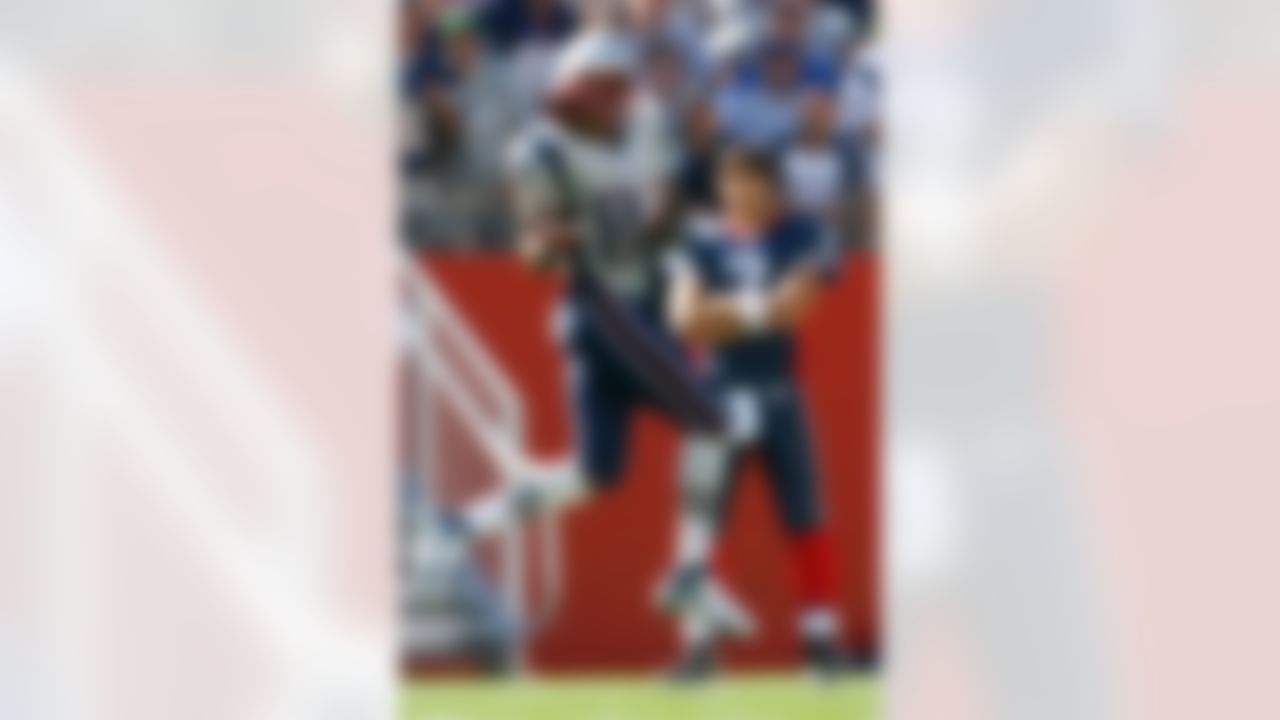 FOXBORO, MA - SEPTEMBER 23: Randy Moss #81 of the New England Patriots grabs a pass as JP Losman #7 of the Buffalo Bills watches from the sideline at Gillette Stadium on September 23, 2007 in Foxboro, Massachusetts. The Patriots defeated the Bills 38-7. (Photo by Jim Rogash/Getty Images)