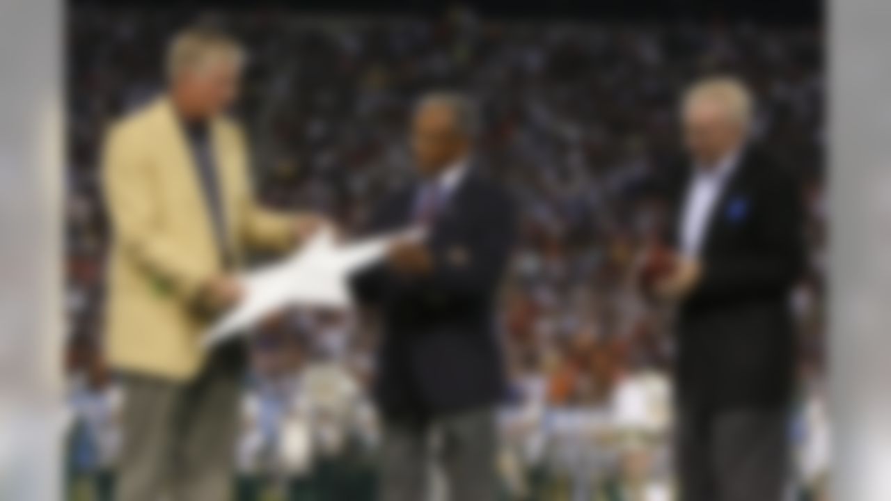 Dallas Cowboys defensive tackle Bob Lilly (left) presents a star from Texas Stadium to Pro Football Hall of Fame representative Steve Perry (center) as Cowboys owner Jerry Jones (right) watches during an NFL preseason football game with the Cincinnati Bengals, Sunday, August 8, 2010 at Pro Football Hall of Fame Field at Fawcett Stadium in Canton, Ohio. The Cowboys won the game, 16-7. (AP Photo/James D Smith)