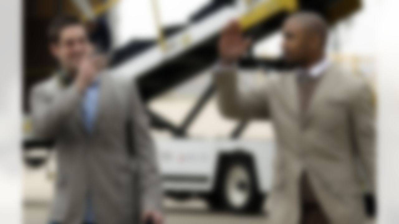Green Bay Packers' Aaron Rodgers, left, shoots video of teammate Charles Woodson as they arrive at Dallas/Fort Worth International Airport for NFL football Super Bowl XLV Monday, Jan. 31, 2011, in Dallas. (AP Photo/Morry Gash)