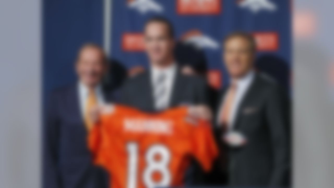 New Denver Broncos quarterback Peyton Manning, center, is flanked by Broncos owner Pat Bowlin, left, and vice president John Elway during a news conference at the NFL Denver Broncos headquarters in Englewood, Colo., on Tuesday, March 20, 2012. (AP Photo/Ed Andrieski)New