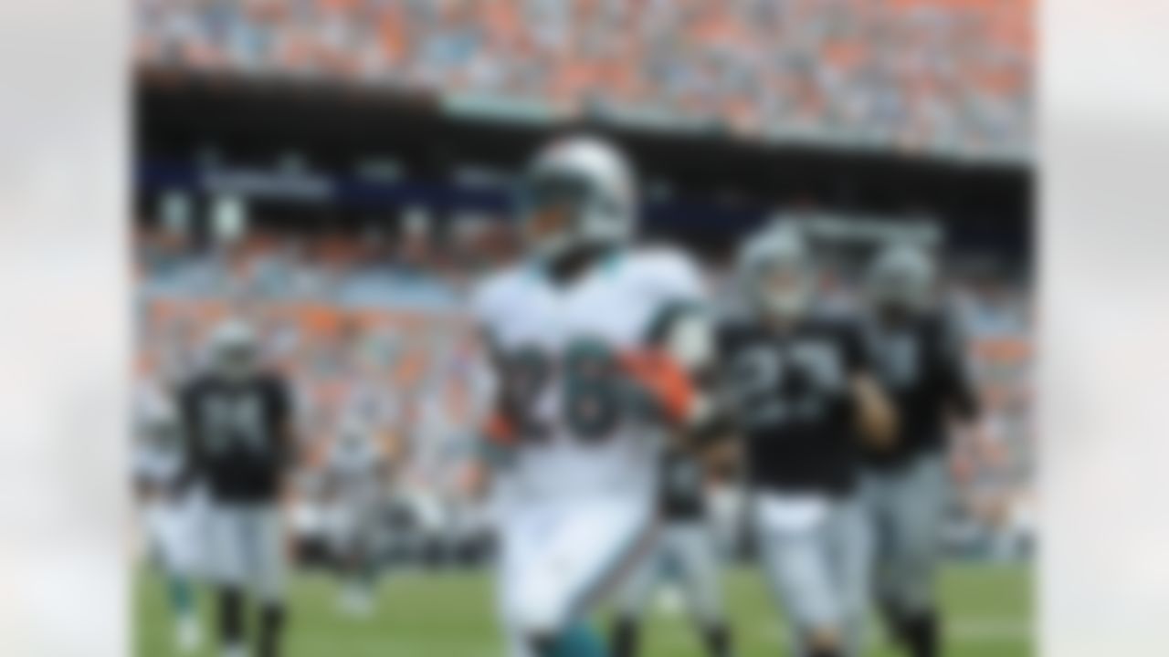 Miami Dolphins Lamar Miller scores a touchdown during the second half of an NFL football game against the Oakland Raiders, Sunday, Sept. 16, 2012 in Miami. (AP Photo/Rhona Wise)