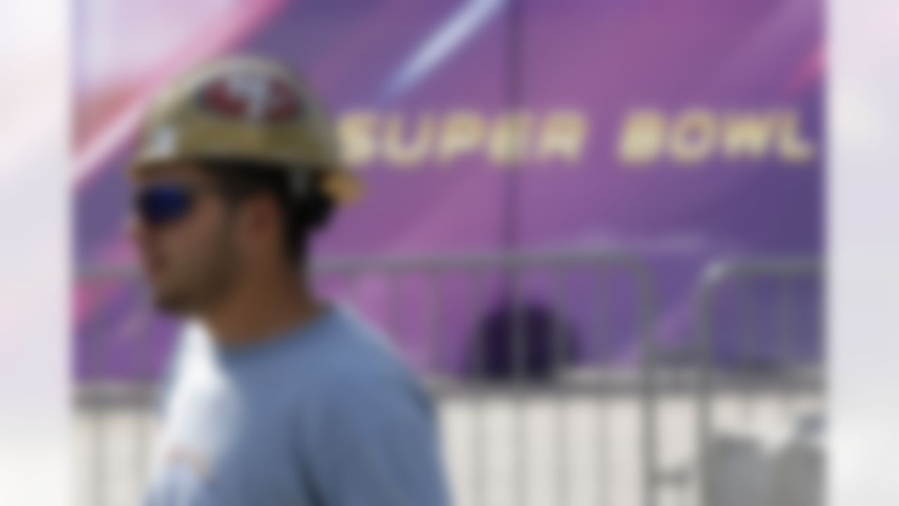 A worker in a San Francisco 49ers hard hat walks outside of the Mercedes-Benz Superdome as preparations take place for the NFL Super Bowl XLVII football game on Sunday, Jan. 27, 2013, in New Orleans. The Baltimore Ravens and San Francisco 49ers are scheduled to play in Super Bowl XLVII on Sunday, Feb. 3. (AP Photo/Patrick Semansky)