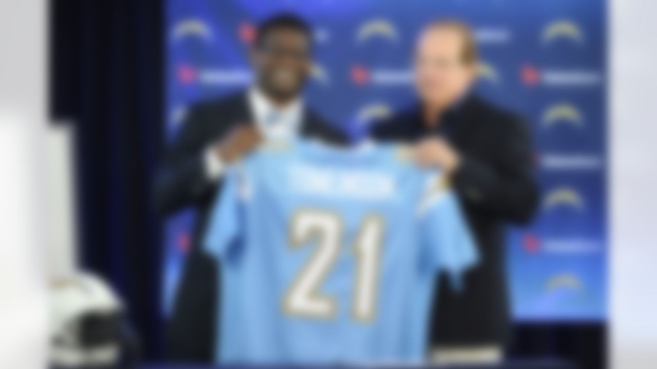 Former San Diego Chargers running back LaDainian Tomlinson, left, and Chargers president Dean Spanos hold up Tomlinson's No. 21 jersey during a news conference at the team's facility, Monday, June 18, 2012, in San Diego. Tomlinson signed a one-day contract with the Chargers and announced his retirement after an 11-year NFL career. Tomlinson finishes his career with 13,684 yards, fifth all-time, and 145 touchdowns. (AP Photo/Denis Poroy)