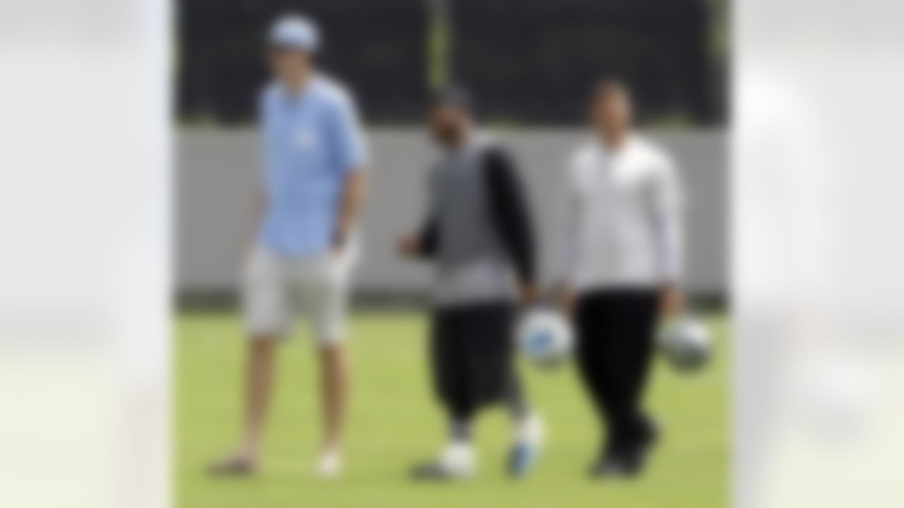 Carolina Panthers' Steve Smith, center, and tennis player John Isner, left, walk off the field with Smith's teammate John Kasay, right, after football practice in Charlotte, N.C., Wednesday, June 2, 2010. (AP Photo/Chuck Burton)