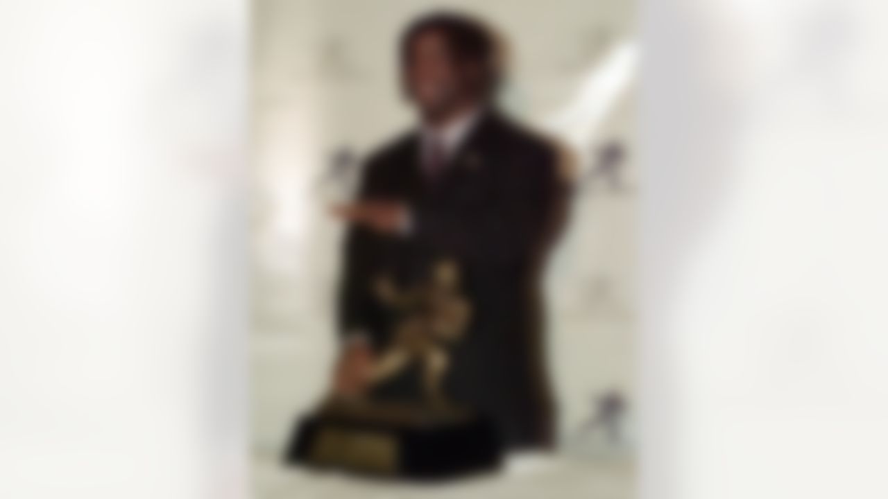 Texas tailback Ricky Williams, winner of the 1998 Heisman trophy, gestures as he listens to a request from photographers as he holds a copy of the Heisman trophy Saturday, Dec. 12, 1998 at the Downtown Athletic Club, in New York. Williams ran for 2,124 yards and broke Tony Dorsett's 22-year-old record career rushing record as he led the Longhorns to an 8-3 record and a trip to the Cotton Bowl on Jan. 1. (AP Photo/Suzanne Plunkett)