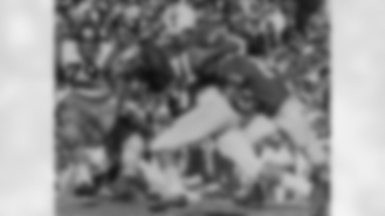 Texas quarterback Duke Carlisle (11) is swarmed by various Navy players during the Cotton Bowl in Dallas, Jan. 1, 1964. Navy tackle James Freeman (79) charges in. (Associated Press)