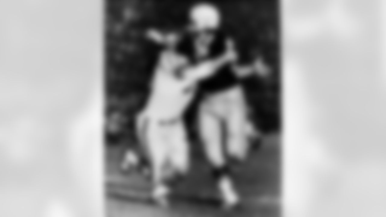 New York Giants' linebacker Sam Huff (70) puts his crushing hug on Green Bay Packers' Jim Taylor (31), Sept. 4, 1962, in Green Bay, Wisconsin. The Packers won, 20-17. (Associated Press)