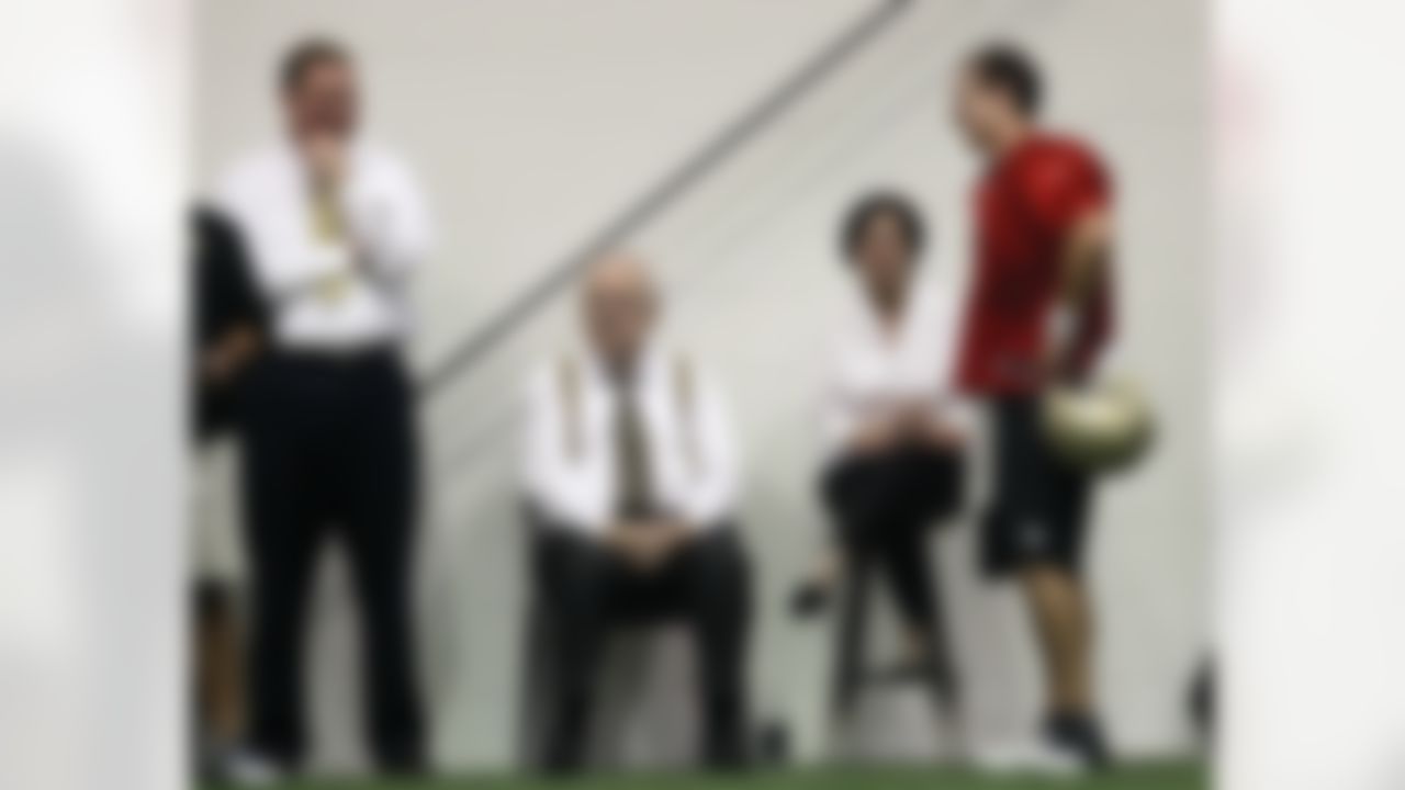 New Orleans Saints quarterback Drew Brees, right, talks with owner Tom Benson, center, his wife Gayle Benson, and team president Dennis Lauscha during the first practice of NFL football training camp at their indoor training facility in Metairie, La., Thursday, July 26, 2012. (AP Photo/Gerald Herbert)