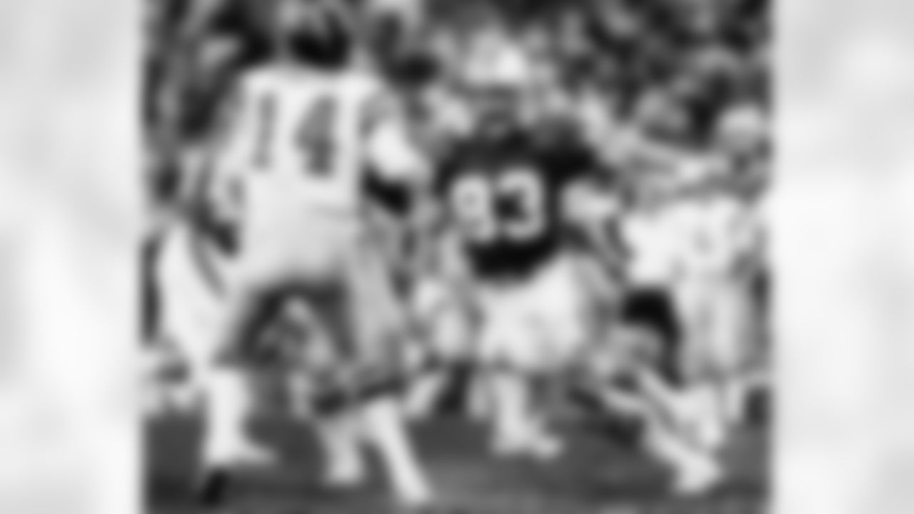 San Diego Chargers quarterback Dan Fouts (14), inducted into the Pro Football Hall of Fame class of 1993, stands tall with Miami Dolphins defensive end Vern Den Herder (83) bearing down on him during the AFC Divisional Playoff, a 41-38 Chargers overtime victory on January 2, 1982, at the Orange Bowl in Miami, Florida. (Photo by Al Messerschmidt/NFL)