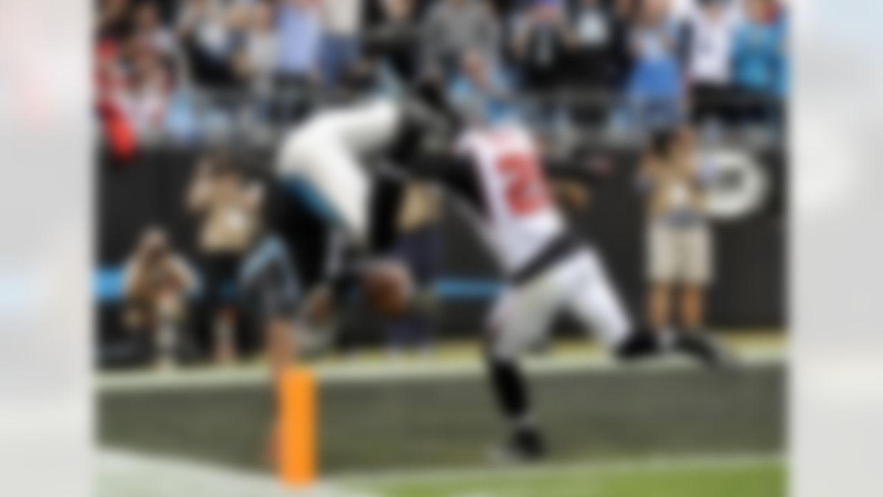 Carolina Panthers quarterback Cam Newton (1) dives into the end zone for a touchdown as Atlanta Falcons' Chris Owens (21) pursues during the second half of an NFL football game in Charlotte, N.C., Sunday, Dec. 9, 2012. (AP Photo/Rainier Ehrhardt)