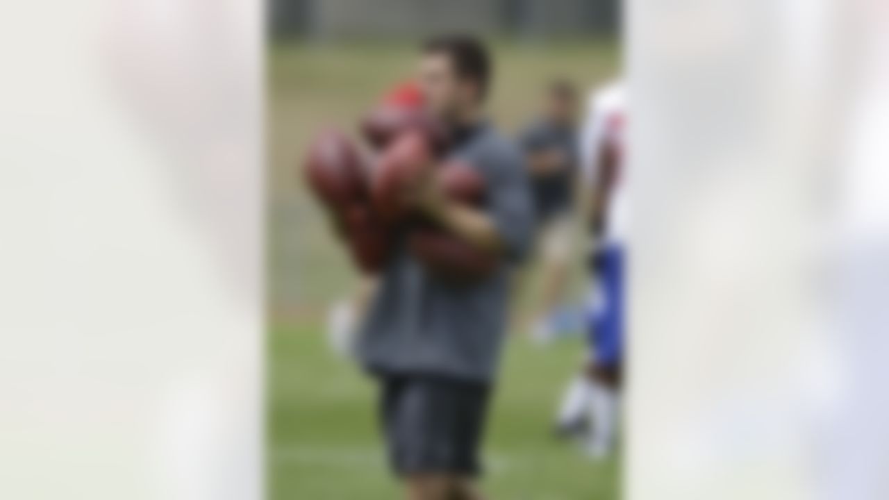 A member of the New York Giants staff carries footballs during an NFL practice at training camp in Albany, N.Y., Friday, July 27, 2012. (AP Photo/Kathy Willens)