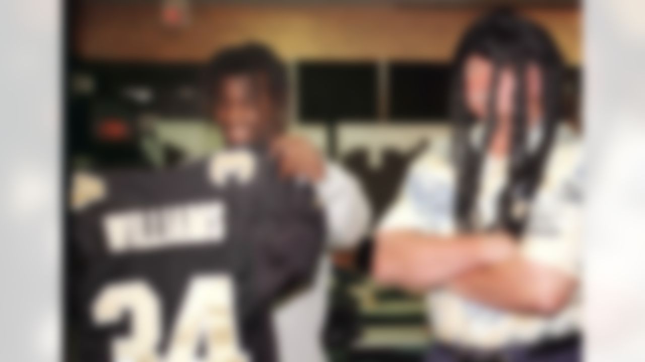 New Orleans Saints first-round draft pick Ricky Williams, left, checks out his New Orleans Saints jersey as coach Mike Ditka, wearing a dreadlock wig, looks on Sunday, April 18,1999 in Kenner, La. The Saints traded all of their draft picks in 1999 and their first- and third-round picks in 2000 to Washington to get the Heisman Trophy winner. (AP Photo/Judi Bottoni)