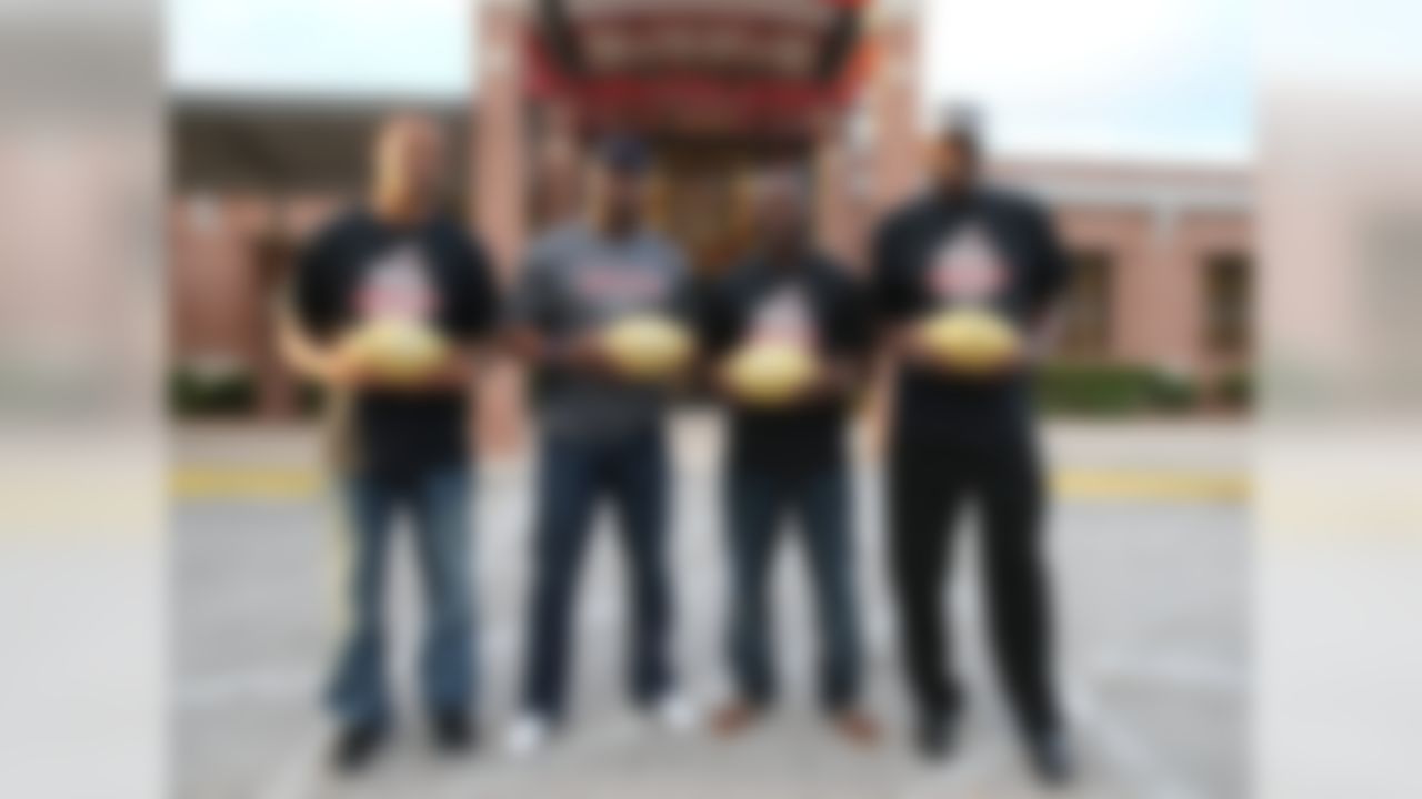 Former NFL players Jabar Gaffney, Brian Dawkins, Lito Sheppard and Harold Carmichael pose for a photo with golden footballs during a Super Bowl High School Honor Roll ceremony at William M. Raines High School on Thursday, Nov. 5, 2015 in Jacksonville, Fla. (Gary McCullough/AP Images for National Football League)