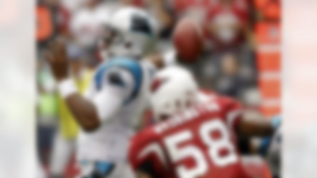 Carolina Panthers quarterback Cam Newton throws his first career touchdown pass as Arizona Cardinals linebacker Daryl Washington (58) pursues during the first half of an NFL football game on Sunday, Sept. 11, 2011, in Glendale, Ariz. (AP Photo/Paul Connors)