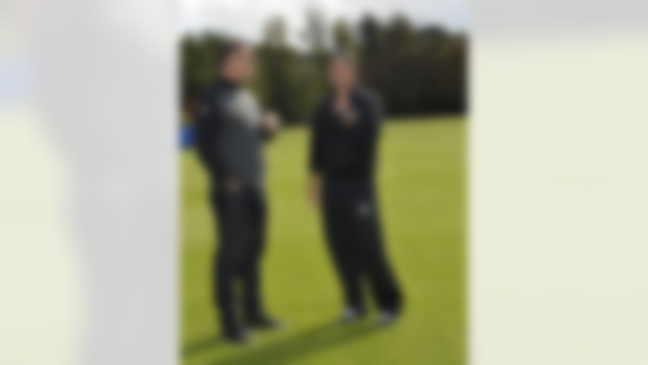Oakland Raiders head coach Dennis Allen (right) talks with former Raider and NFL Hall of Famer Howie Long after practice on Wednesday, September 24, 2104 at Pennyhill Park outside of London. The Oakland Raiders and the Miami Dolphins will play in the NFL International Series at Wembley Stadium in London on Sunday, Sept 28. (Sean RyanNFL)