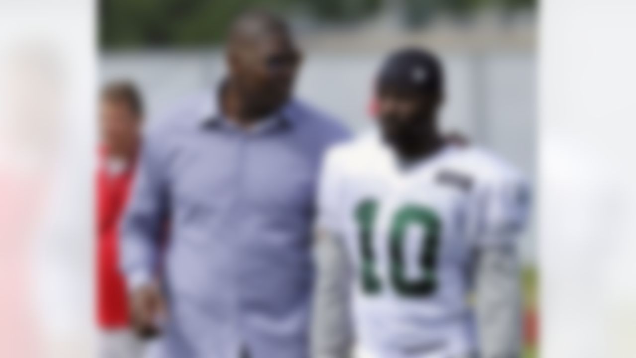 Former New York Jets receiver Keyshawn Johnson, left, talks with Jets wide receiver Santonio Holmes after practice on opening day of their NFL football training camp Friday, July 27, 2012, in Cortland, N.Y. (AP Photo/Bill Kostroun)