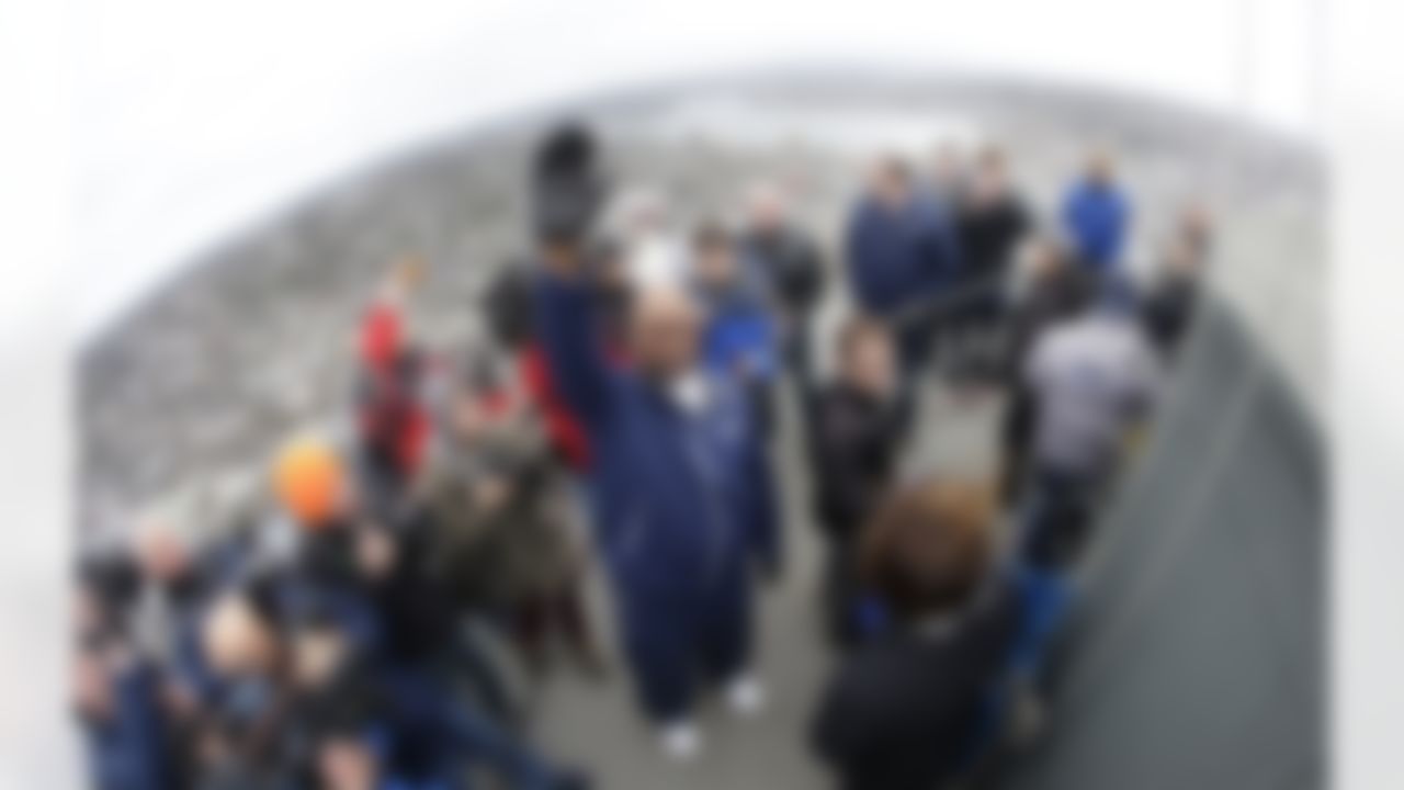 In this photo made with a fisheye lens, former Seattle Seahawks defensive tackle Cortez Kennedy, center, waves as he arrives to raise the Seahawks' 12th Man flag on the roof of the Space Needle, Friday, Jan. 10, 2014, in Seattle. The Seahawks will host the New Orleans Saints in an NFL football second-round playoff game on Saturday. (AP Photo/Ted S. Warren)