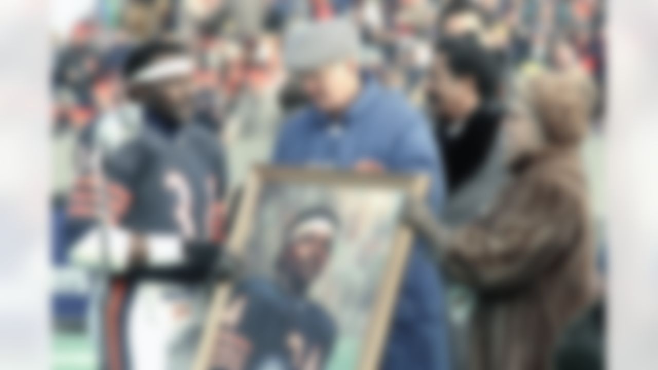 Chicago Bears running back Walter Payton receives a painting of his likeness from Bears owners Ed and Virginia McCaskey during pre-game ceremonies in Chicago, on Sunday, Dec. 20, 1987. (Mark Elias/Associated Press)