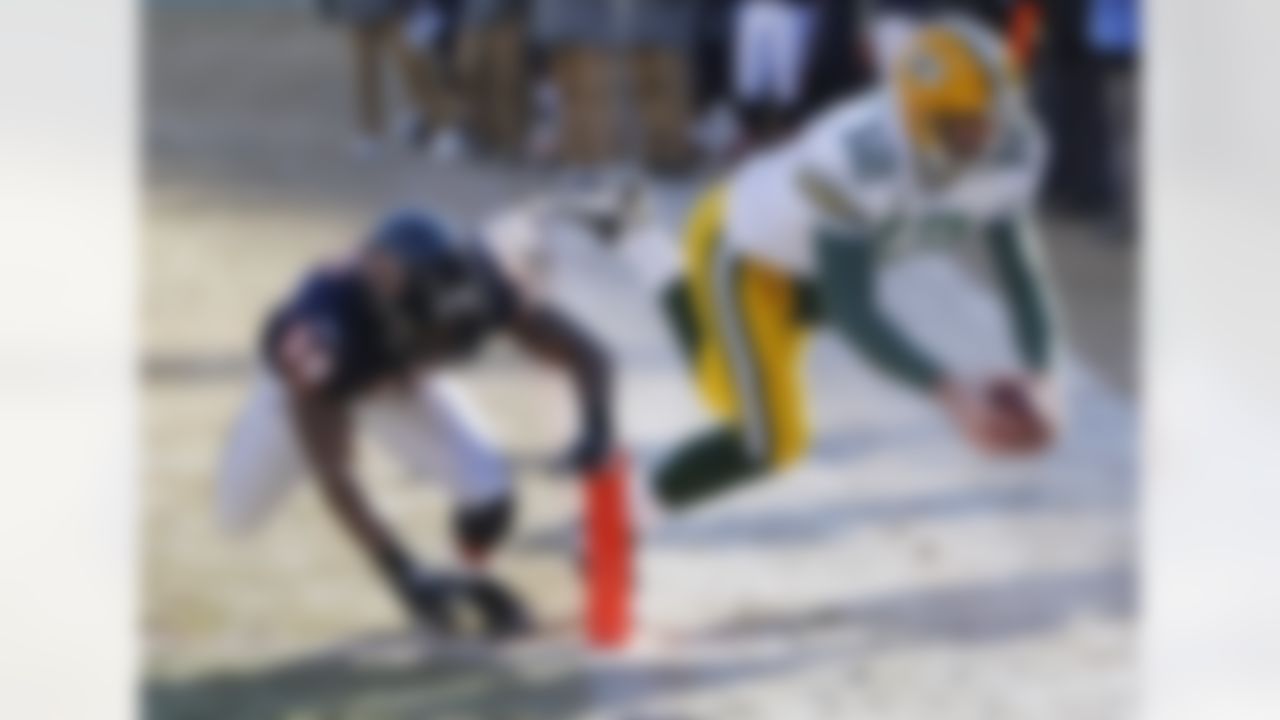 Green Bay Packers quarterback Aaron Rodgers (12) scores a touchdown past Chicago Bears safety Danieal Manning (38) during the first half of the NFC Championship NFL football game Sunday, Jan. 23, 2011, in Chicago. (AP Photo/Charles Rex Arbogast)