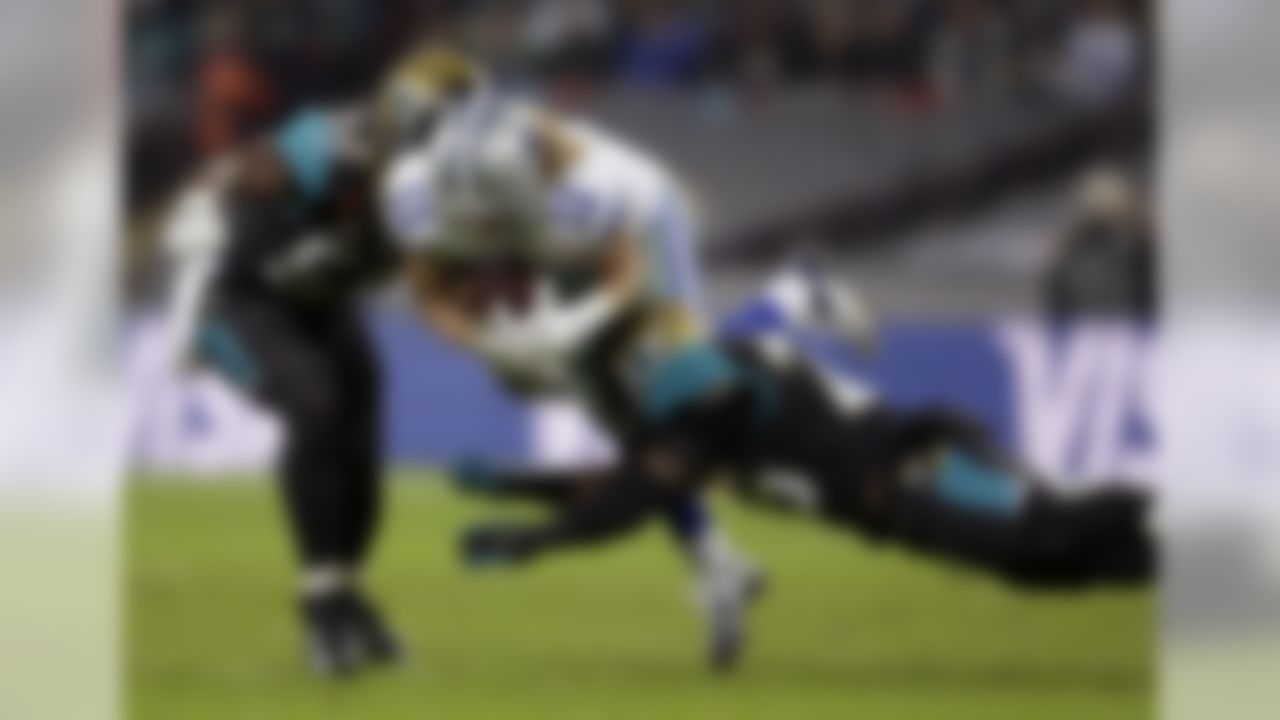 Dallas Cowboys wide receiver Cole Beasley (11) is tackled by Jacksonville Jaguars outside linebacker J.T. Thomas (52) and free safety Josh Evans (26) during the first half of an NFL football game at Wembley Stadium, London, Sunday, Nov. 9, 2014. (AP Photo/Matt Dunham)
