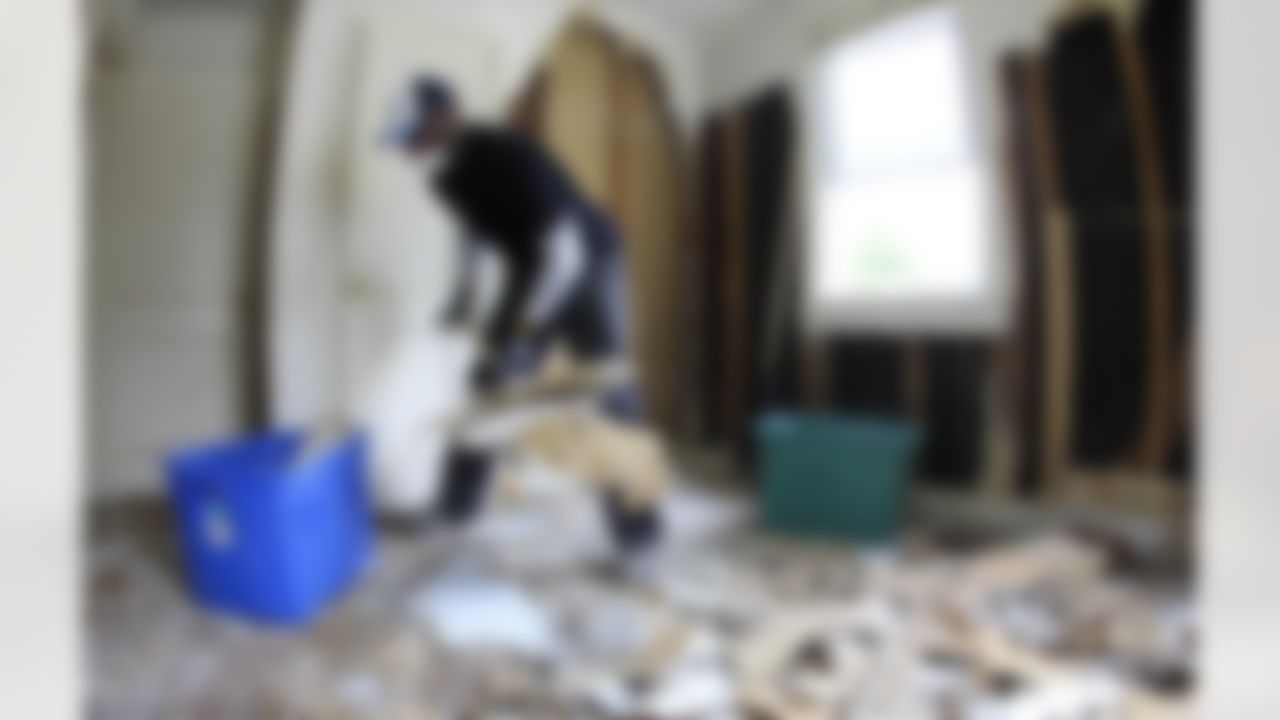 Tennessee Titans linebacker Gerald McRath removes drywall from a house as Titans players, coaches and staff help to clean up homes damaged by floods on Wednesday, May 12, 2010, in Nashville, Tenn. (AP Photo/Mark Humphrey)