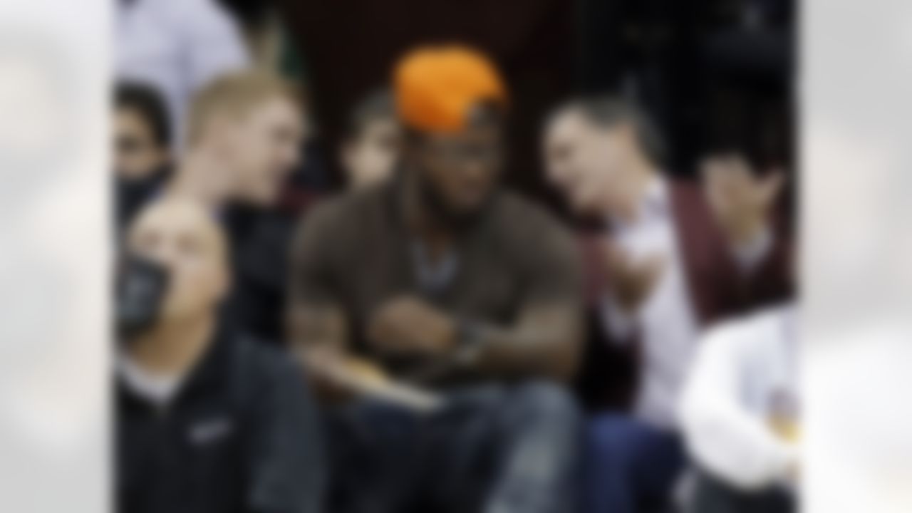 Cleveland Cavaliers owner Dan Gilbert, right, talks with Cleveland Browns running back Trent Richardson, center, and quarterback Brandon Weeden, left, during the fourth quarter of the Cavaliers' NBA basketball game against the Washington Wizards on Tuesday, Oct. 30, 2012, in Cleveland. Gilbert watched his team win its season opener, 94-84. (AP Photo/Mark Duncan)