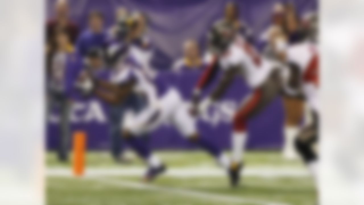 Minnesota Vikings wide receiver Percy Harvin, left, catches an 18-yard touchdown pass ahead of Tampa Bay Buccaneers cornerback Eric Wright, right, during the first half of an NFL football game Thursday, Oct. 25, 2012, in Minneapolis. (AP Photo/Andy King)