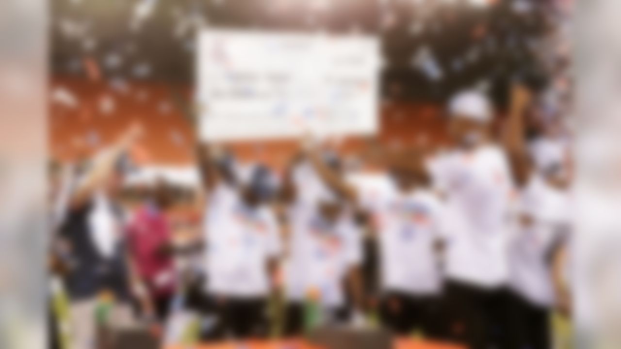 Team Fighting Cancer celebrate while holding up their million-dollar check as confetti falls after they win the American Flag Football League (AFFL) U.S. Open of Football Ultimate Championship.