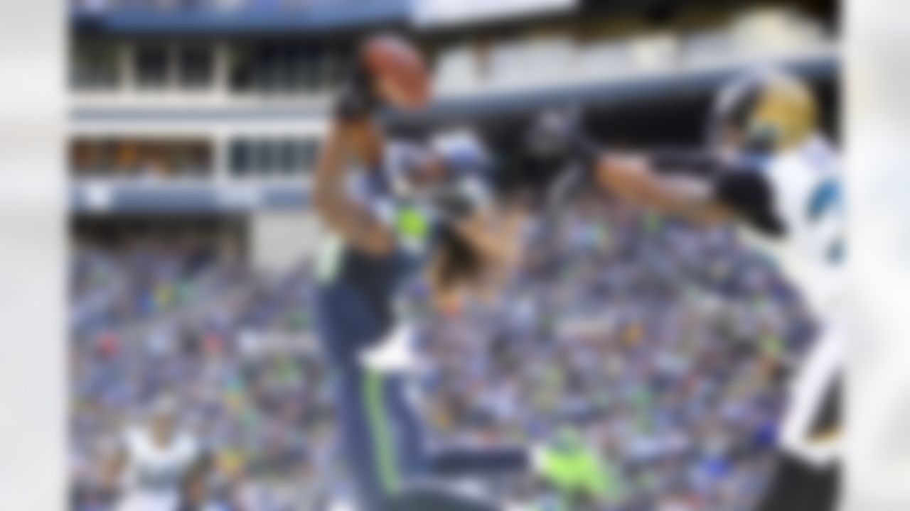 Seattle Seahawks' Sidney Rice, front left, snags the ball in the end zone for a touchdown in front of Jacksonville Jaguars' Josh Evans in the second half of an NFL football game on Sunday, Sept. 22, 2013, in Seattle. (AP Photo/Stephen Brashear)