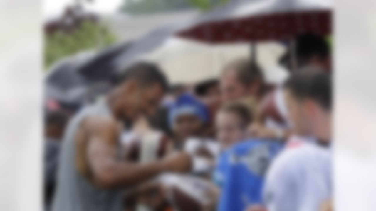 New York Giants wide receiver Domenik Hixon, left, laughs as he signs autographs for fans during autograph day following practice at the NFL football team's training camp in Albany, N.Y., Saturday, July 28, 2012. (AP Photo/Kathy Willens)