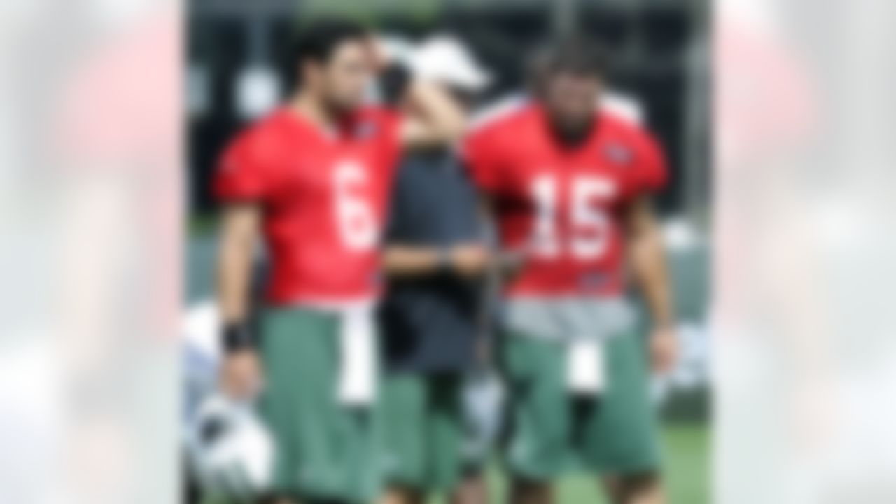 New York Jets quarterbacks coach Matt Cavanaugh talks with quarterbacks Mark Sanchez, left, and Tim Tebow, right, during practice on opening day of their NFL training camp Friday, July 27, 2012, in Cortland, N.Y. (AP Photo/Bill Kostroun)